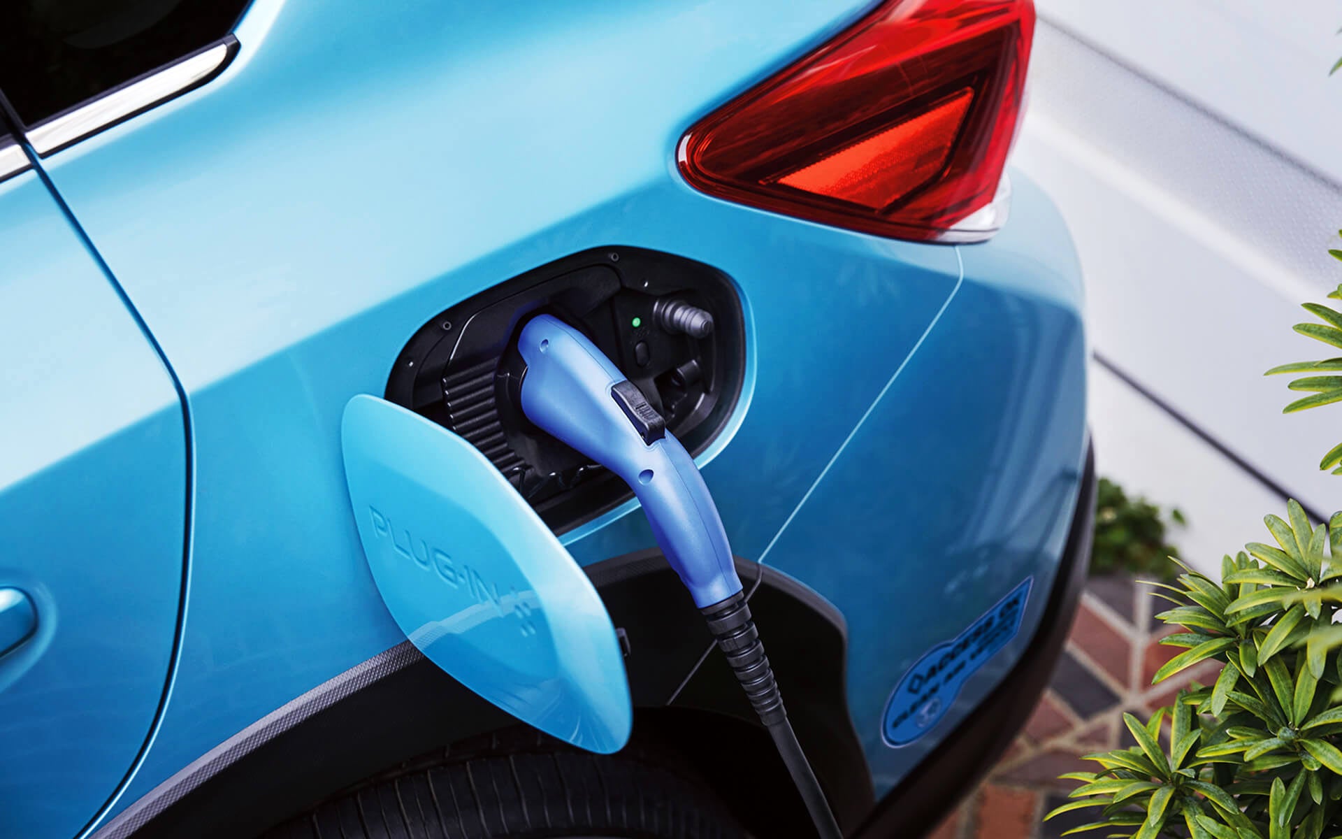 A close-up of the Subaru Crosstrek Hybrid's charging port with charging cable plugged in | Stevens Creek Subaru in Santa Clara CA